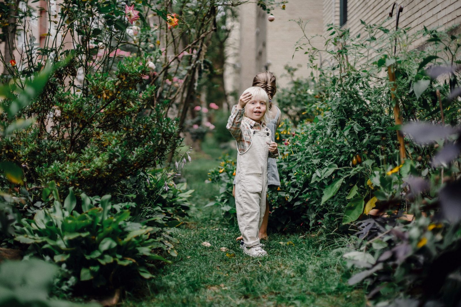 Twee kinderen spelen in de omheinde tuin van een gezinswoning tijdens een vakantieruil