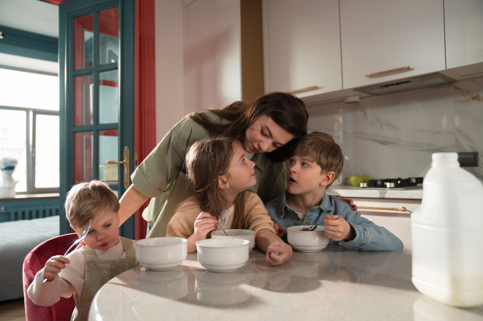 Een moeder en haar drie kinderen ontbijten in de keuken van een geruild huis